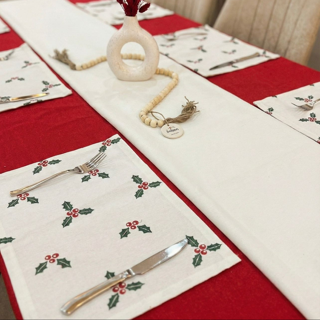 Dining table set with Christmas-themed placemats and decorations.
