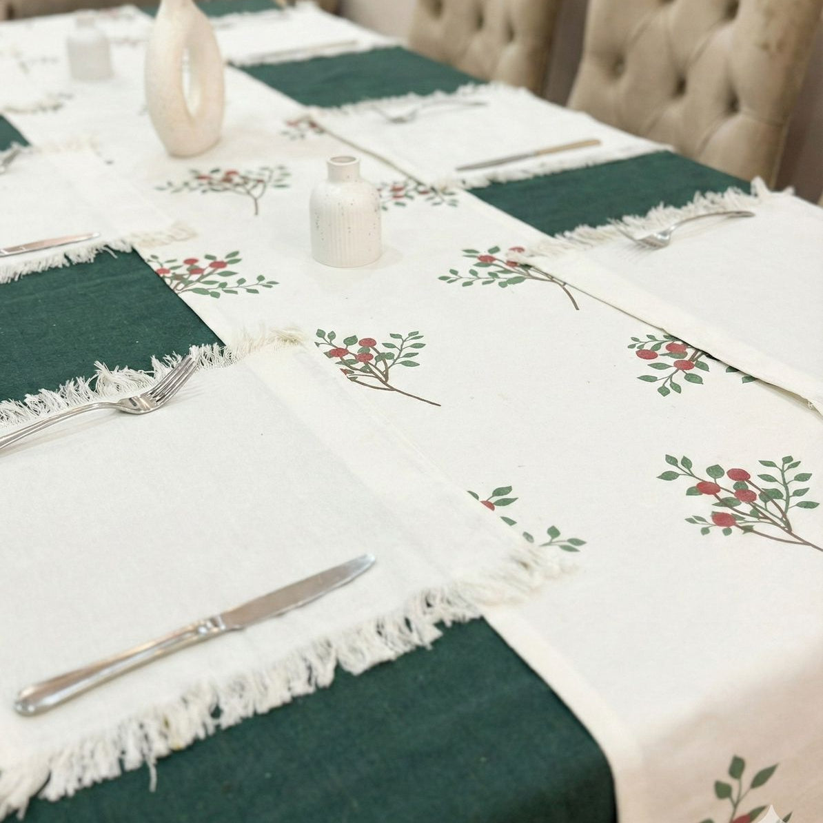 Dining table set with a floral tablecloth and green placemats.