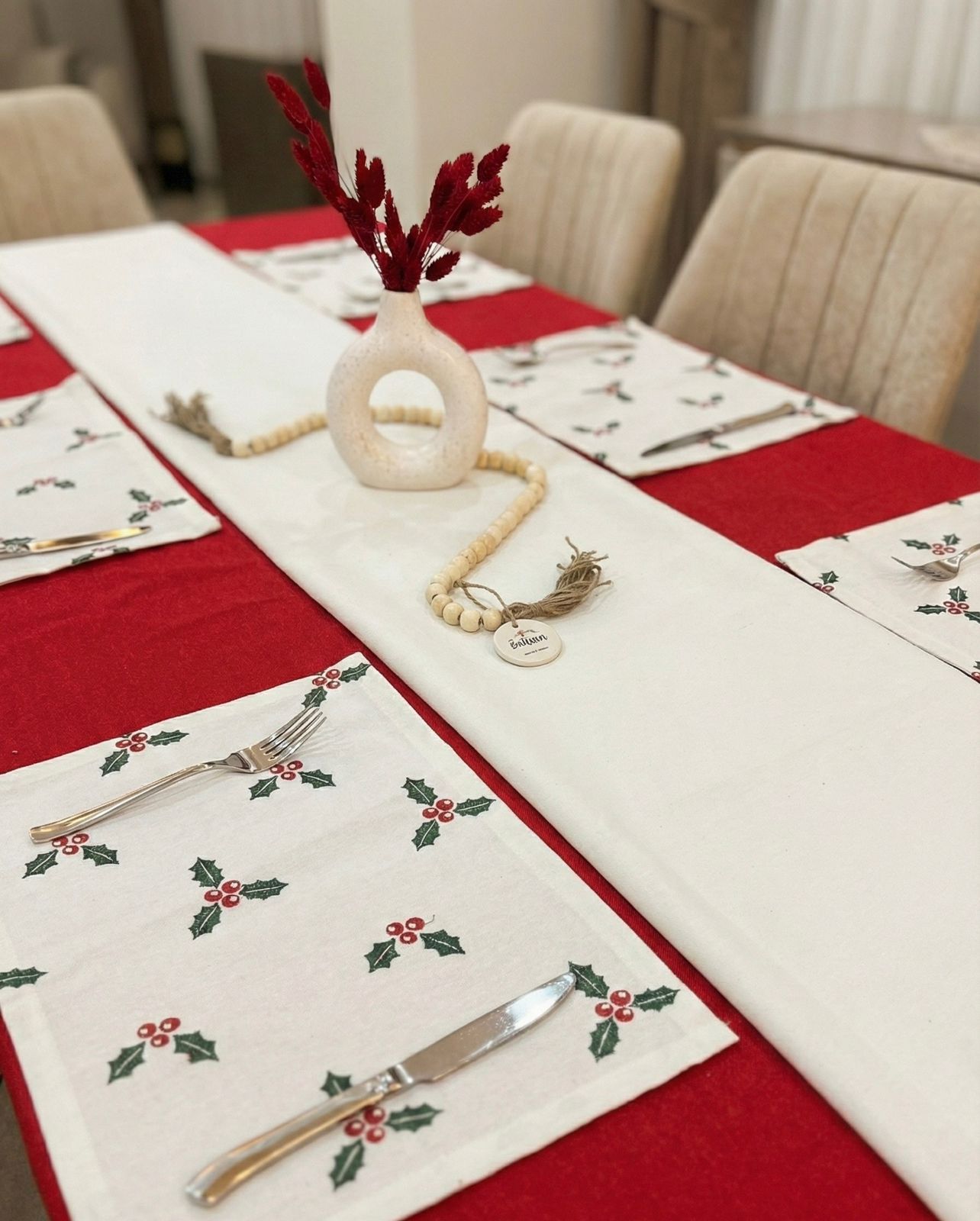 Dining table set with Christmas-themed placemats and decorations.