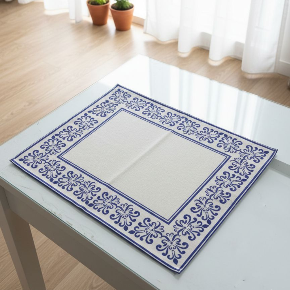 Decorative blue and white patterned placemat on a glass table.