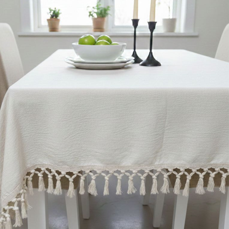 Dining table with a white tablecloth and decorative elements in a bright room.