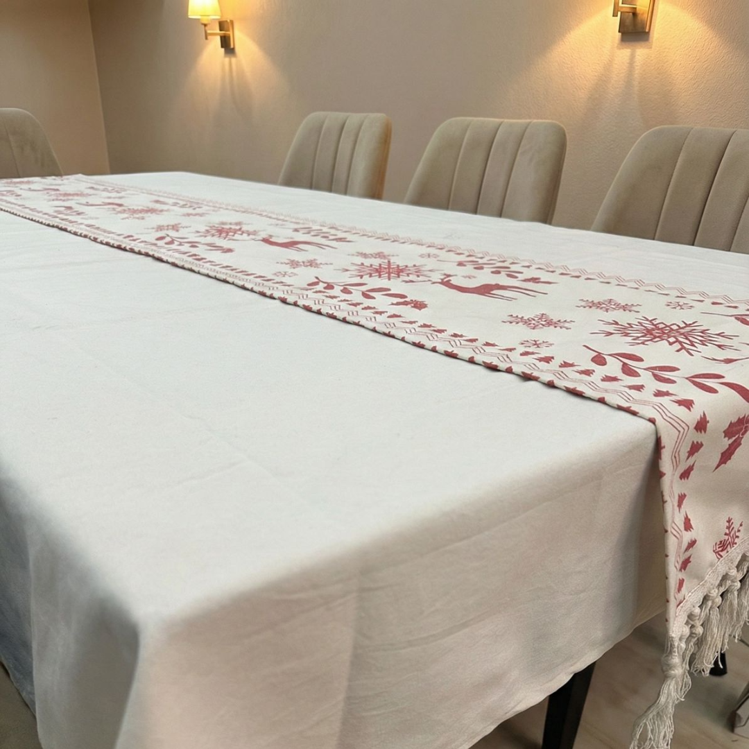 Table runner with deer and tree pattern on a white tablecloth