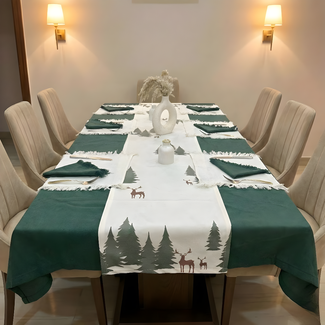 Dining table set with green tablecloth and deer-themed runner, surrounded by beige chairs.