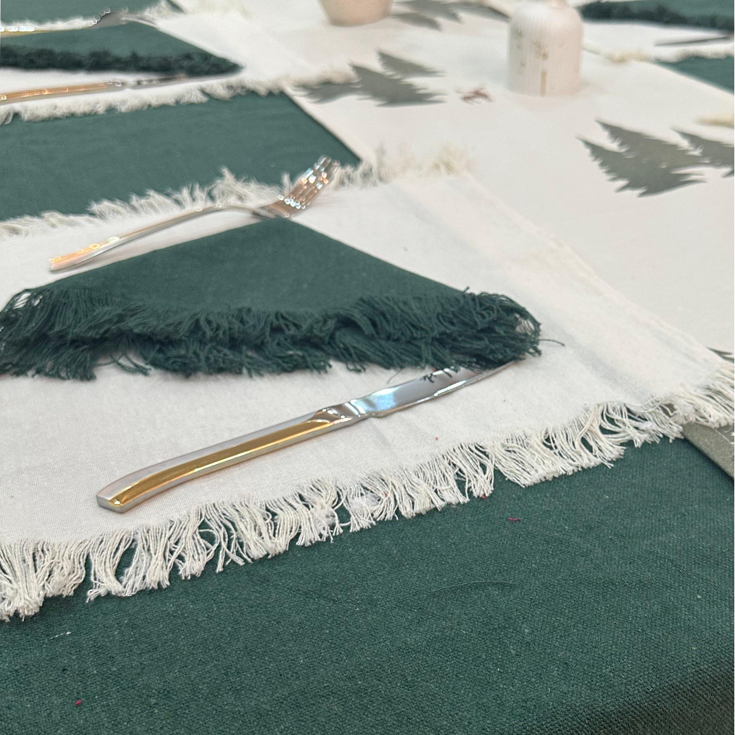 Knife and fork on a green tablecloth with white fringe